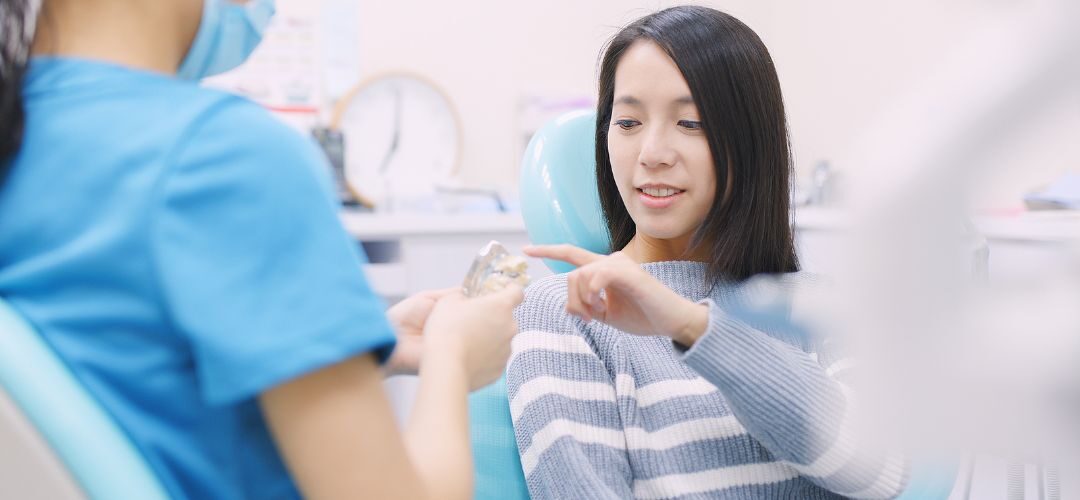 A patient pointing to a place with an implant on an educational figure, asking a question.